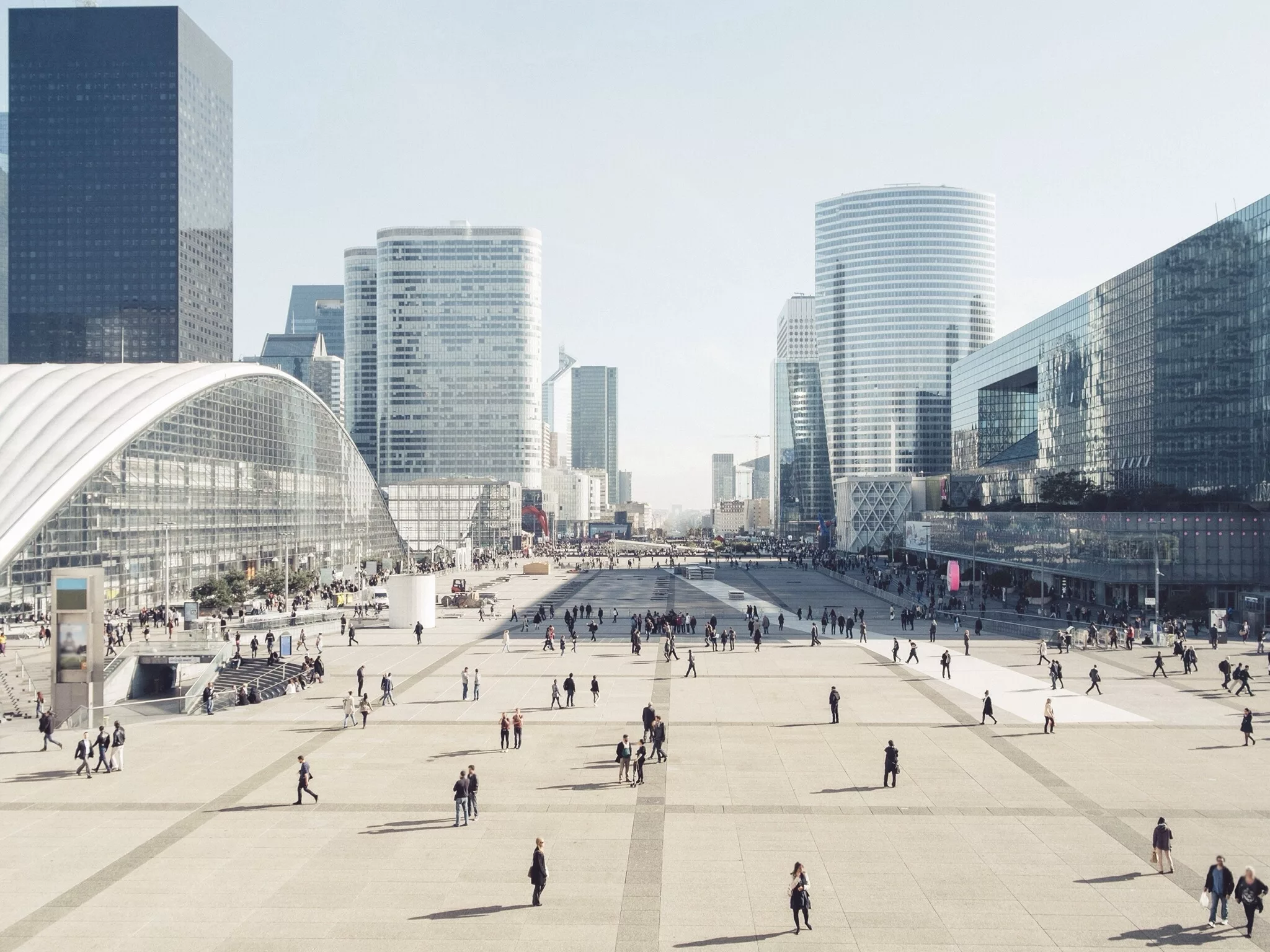 High Angle View Of People On Street Amidst Modern Buildings Against Clear Sky